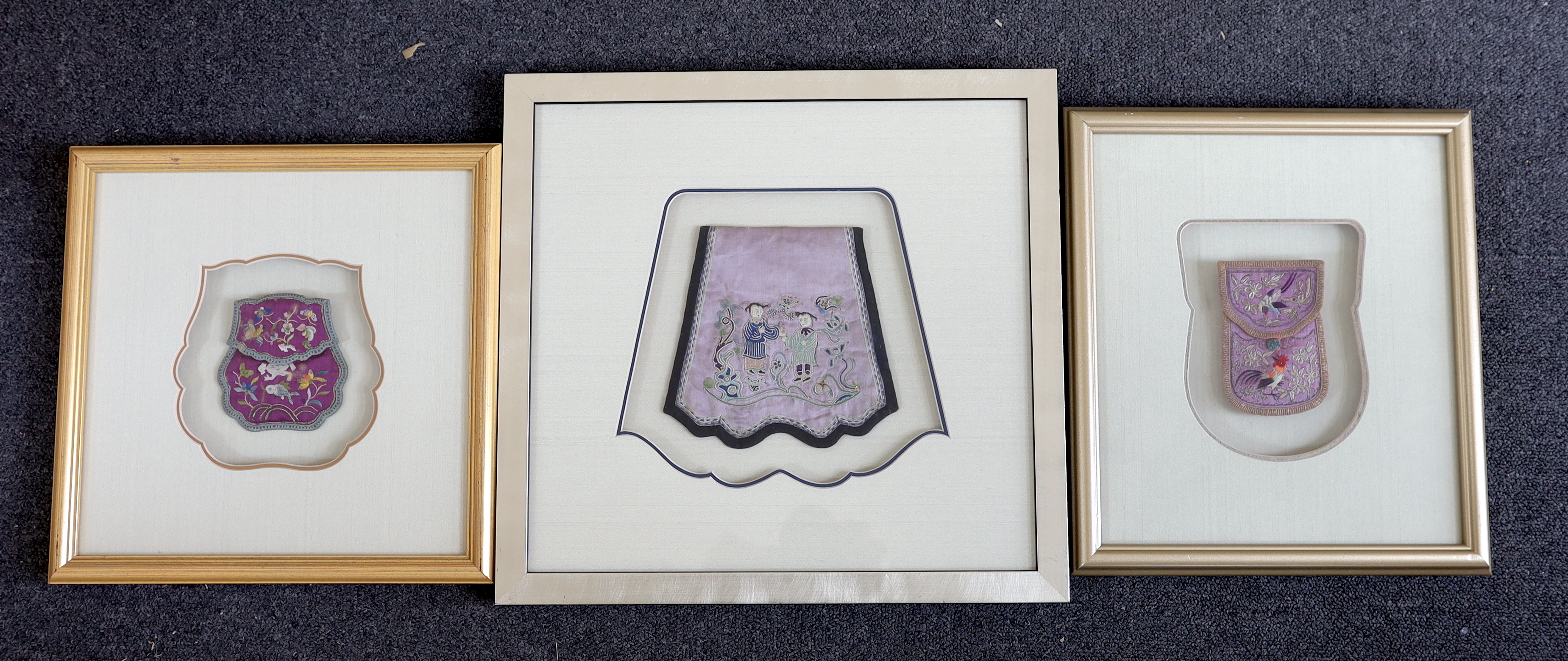 A late 19th century Chinese purple silk purse, embroidered with a sage, fish, butterflies and flowers, another silk purse embroidered in silver metal thread and polychromes silk threads, together with a similar figurativ